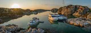 Boats and sailboat moored up in the sunset in Norway