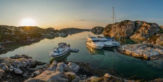 Boats and sailboat moored up in the sunset in Norway